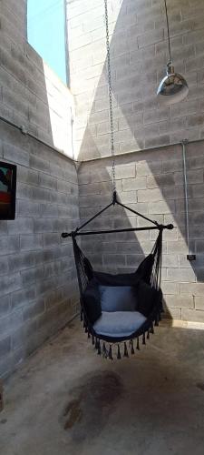 a black hammock hanging in a room with a brick wall at Casa Tapanco Tepoztlán in Tepoztlán