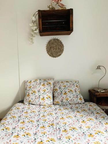 - une chambre avec un lit et une couette en fleurs dans l'établissement Appartement de charme Centre ville/Halles/quartier haut, à Sète
