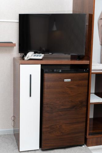 a tv on top of a wooden entertainment center at Cube House Osh in Osh