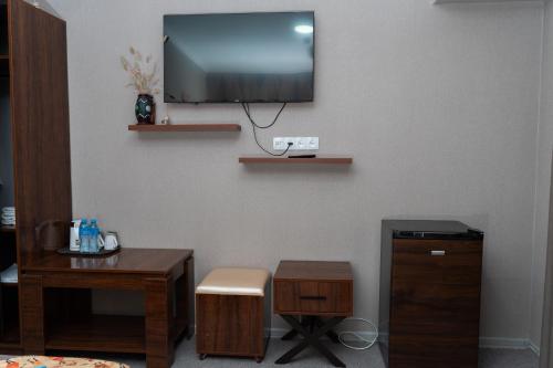 a room with a desk and a tv on a wall at Cube House Osh in Osh