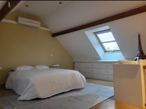 um quarto com uma cama branca e uma janela em Golf House in Paris em Noisy-le-Roi