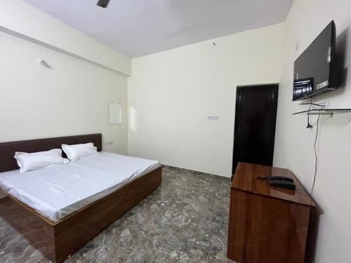 a bedroom with a bed and a flat screen tv at Bharat hotel in Ambikāpur