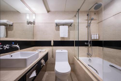 a bathroom with a sink and a toilet and a shower at Sunworld Hotel Wangfujing in Beijing