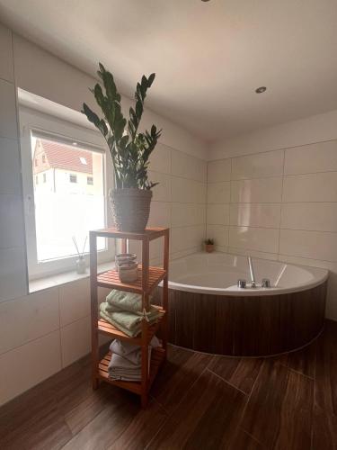 a bathroom with a tub and a potted plant at Ferienwohnung Papststeinblick in Kurort Gohrisch