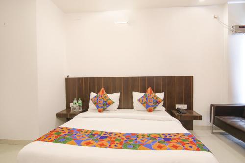 um quarto com uma cama grande e uma cabeceira em madeira em FabExpress Ero sky Palace em Nova Deli
