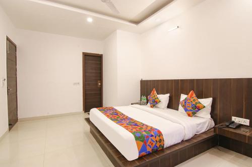 um quarto com uma cama grande e uma cabeceira em madeira em FabExpress Ero sky Palace em Nova Deli