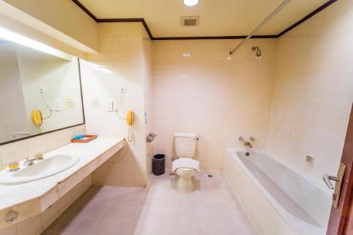 y baño con lavabo, aseo y bañera. en Adika Hotel Bahtera en Klandasan Kecil