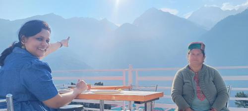 a man and a woman sitting at a table at Kin Vatika Homestay in Kalpa