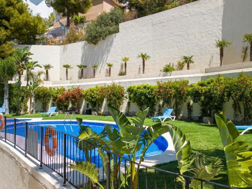 a resort with a swimming pool and palm trees at Belvilla by OYO Casa Panorama Altea Hills in Altea la Vieja