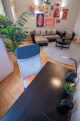 a living room with a table and a blue chair at Be a Budapester in Budapest
