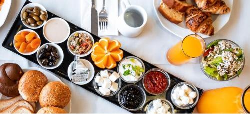 una mesa con un montón de diferentes tipos de alimentos para el desayuno en Mia Glamping Kinneret, en HaOn