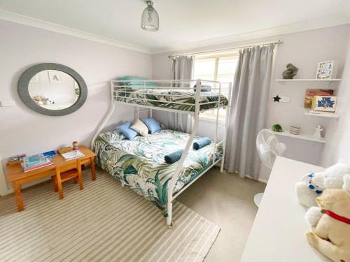 een slaapkamer met een stapelbed en een tafel bij Tuncurry tranquility PID -STRA - 59456 in Tuncurry