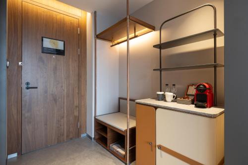 a small kitchen with a closet and a door at UrCove by Hyatt Tianjin West Railway STN in Tianjin