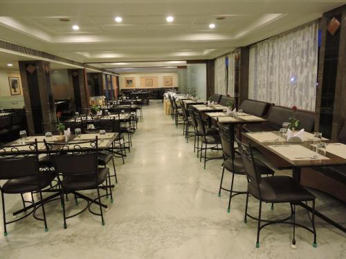 a row of tables and chairs in a restaurant at Hotel PLR Grand in Tirupati
