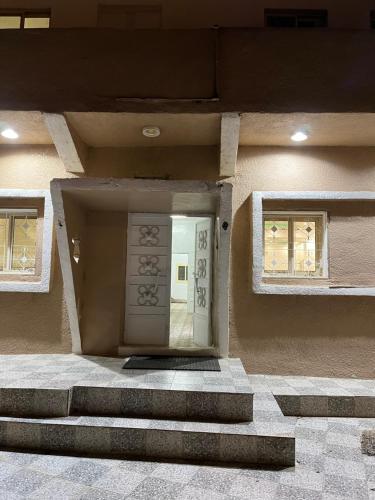 بيت ريفي في Muqammar: باب امامي لمبنى فيه سلالم