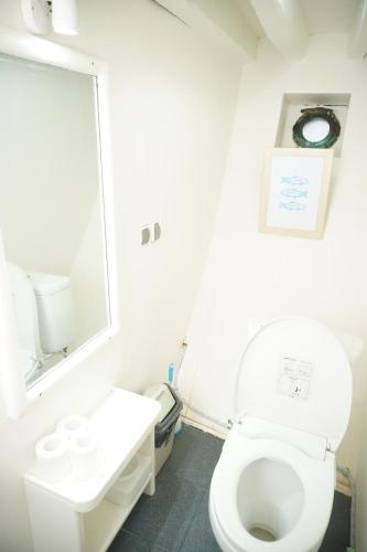 ein Badezimmer mit einem weißen WC und einem Spiegel in der Unterkunft Leticia Liveaboard in Labuan Bajo
