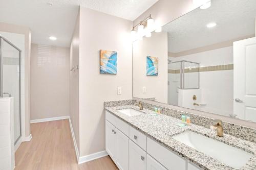 a bathroom with two sinks and a large mirror at Upscale 3BR Condo - Family Resort - Pool And Hot Tub! in Orlando