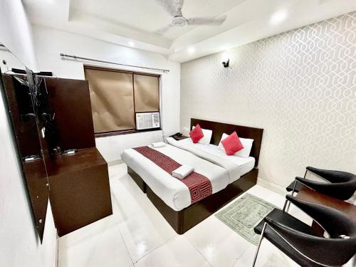 una camera da letto con un letto con cuscini rossi di The Tomar Hospitality a Nuova Delhi
