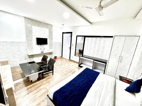 Dormitorio con cama, escritorio y TV en The Tomar Hospitality, en Nueva Delhi