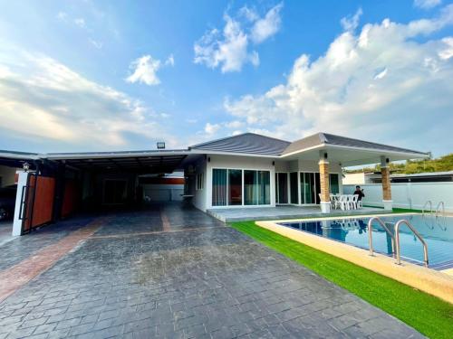 a house with a swimming pool in front of it at Saeng Neua Pool Villa Kaeng Krachan แสงเหนือพูลวิลล่าแก่งกระจาน in Kaeng Krachan