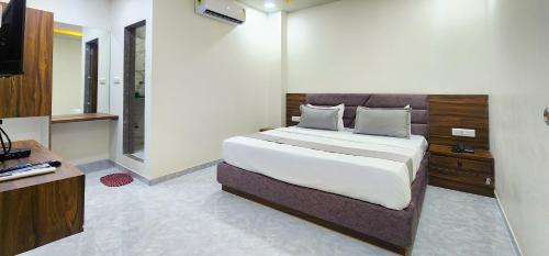 a bedroom with a large bed and a television at Hotel Nova Blue in Ahmedabad