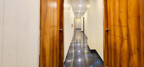 a hallway with two wooden doors and a long aisle at Hotel Nova Blue in Ahmedabad
