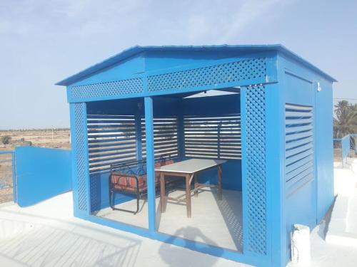 a blue structure with a table and a table at Villa Yahia Djerba in Bou Menjel