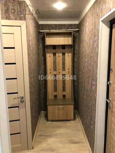 einen begehbaren Kleiderschrank mit einer Tür und einem Zimmer in der Unterkunft Комфортные аппартаменты in Qaraghandy