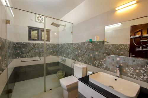 a bathroom with a sink and a toilet and a shower at Krishnatheeram Ayur Holy Beach Resorts in Varkala