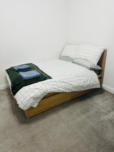 a bed in a bedroom with a white and wooden frame at City Dreams in Croydon