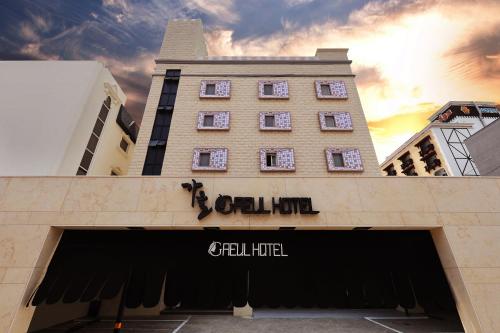 a tall building with a sign over a garage at Gaeul Hotel in Chungju