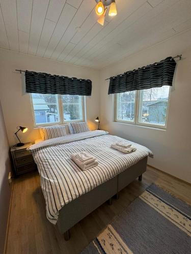 a bedroom with a bed with two towels on it at Luonto Lähellä Residence in Vantaa