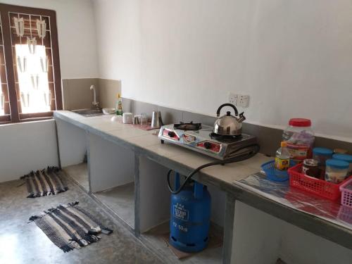 una cocina con encimera y hervidor de agua. en Holiday Bungalow for rent, Inuvil, Jaffna en Uduvil