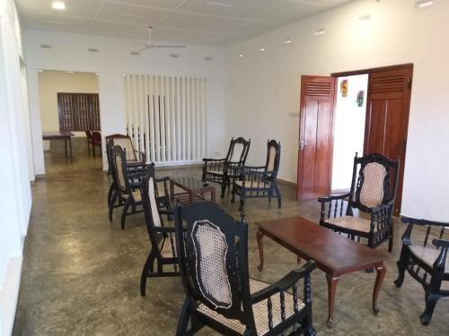Holiday Bungalow for rent, Inuvil, Jaffna في Uduvil: مجموعة من الكراسي والطاولات في الغرفة