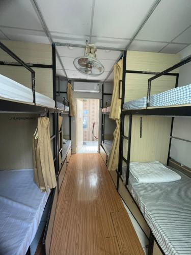 a room with three bunk beds and a hallway at LATALAND HOSTEL in Ho Chi Minh City