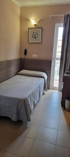 1 dormitorio con 1 cama en una habitación con ventana en Hotel Costa Mediterraneo en El Arenal