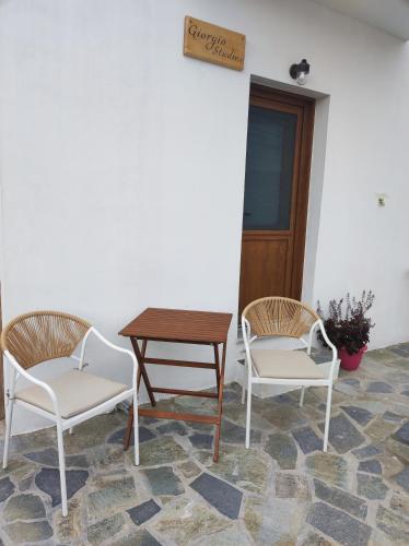two chairs and a table and a table and chairs at Giorgio studios II in Kokkari