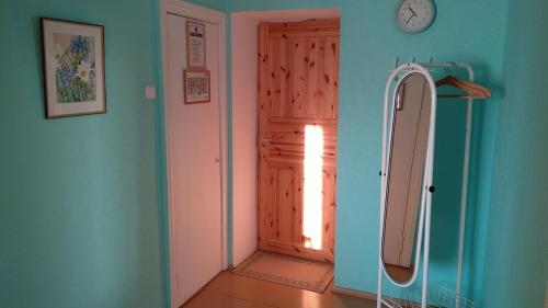 een badkamer met een douche en een klok aan de muur bij K15HOSTEL guest apartments in Kobela