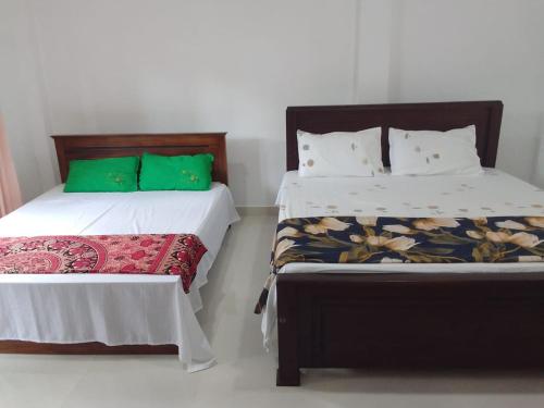 two beds sitting next to each other in a room at Bosadi Homestay in Katunayake