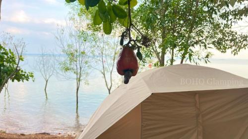 a white tent in front of a body of water at BOHO Glamping in Ấp Phú Cát