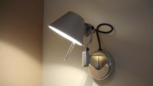 a lamp hanging on a wall with a mirror at Residence CaFelicita - Apartments Lake View - Infinity Pool - Jacuzzi in Gravedona