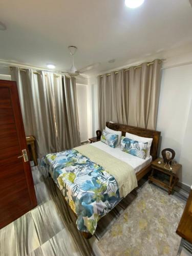 a bedroom with a large bed with blue pillows at maasaifari cozy homes in Dar es Salaam