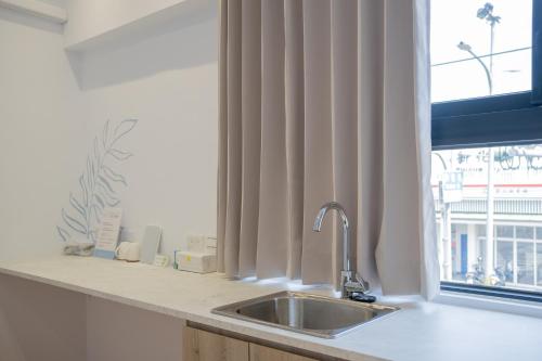 a kitchen counter with a sink and a window at Suite 宿特 I 鄰近武聖夜市 in Hsin-t'ing