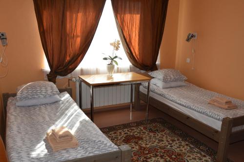 K15HOSTEL guest apartments في Kobela: غرفة بسريرين وطاولة ونافذة