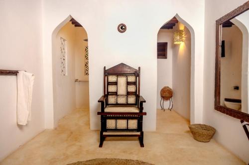 a room with a chair and a mirror on the wall at The Cabanas Lamu in Lamu