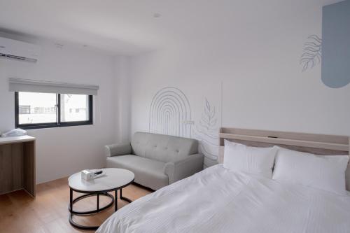 a bedroom with a bed and a couch and a table at Suite 宿特 I 鄰近武聖夜市 in Hsin-t'ing