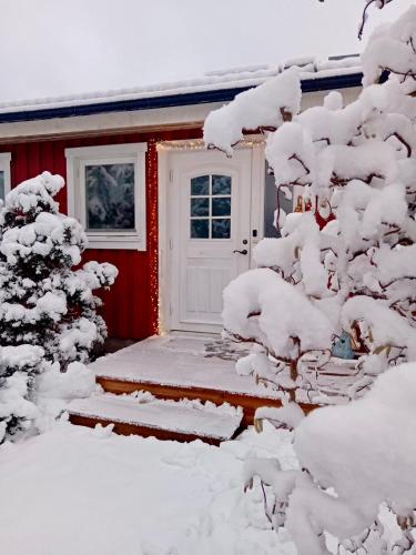 a red house with a door covered in snow at Modernes frisch renoviertes Haus mit gratis Internet in Fagerhult