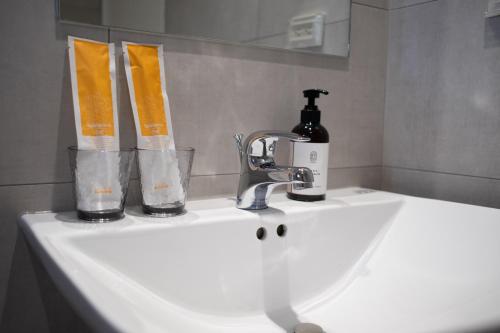 a sink with a bottle of soap and two tooth brushes at Suite 宿特 I 鄰近武聖夜市 in Hsin-t'ing