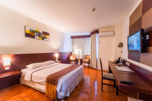 Pokój hotelowy z łóżkiem i biurkiem w obiekcie Adika Hotel Bahtera w mieście Klandasan Kecil