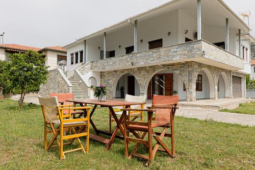 a wooden table and chairs in front of a building at Arches in Agria